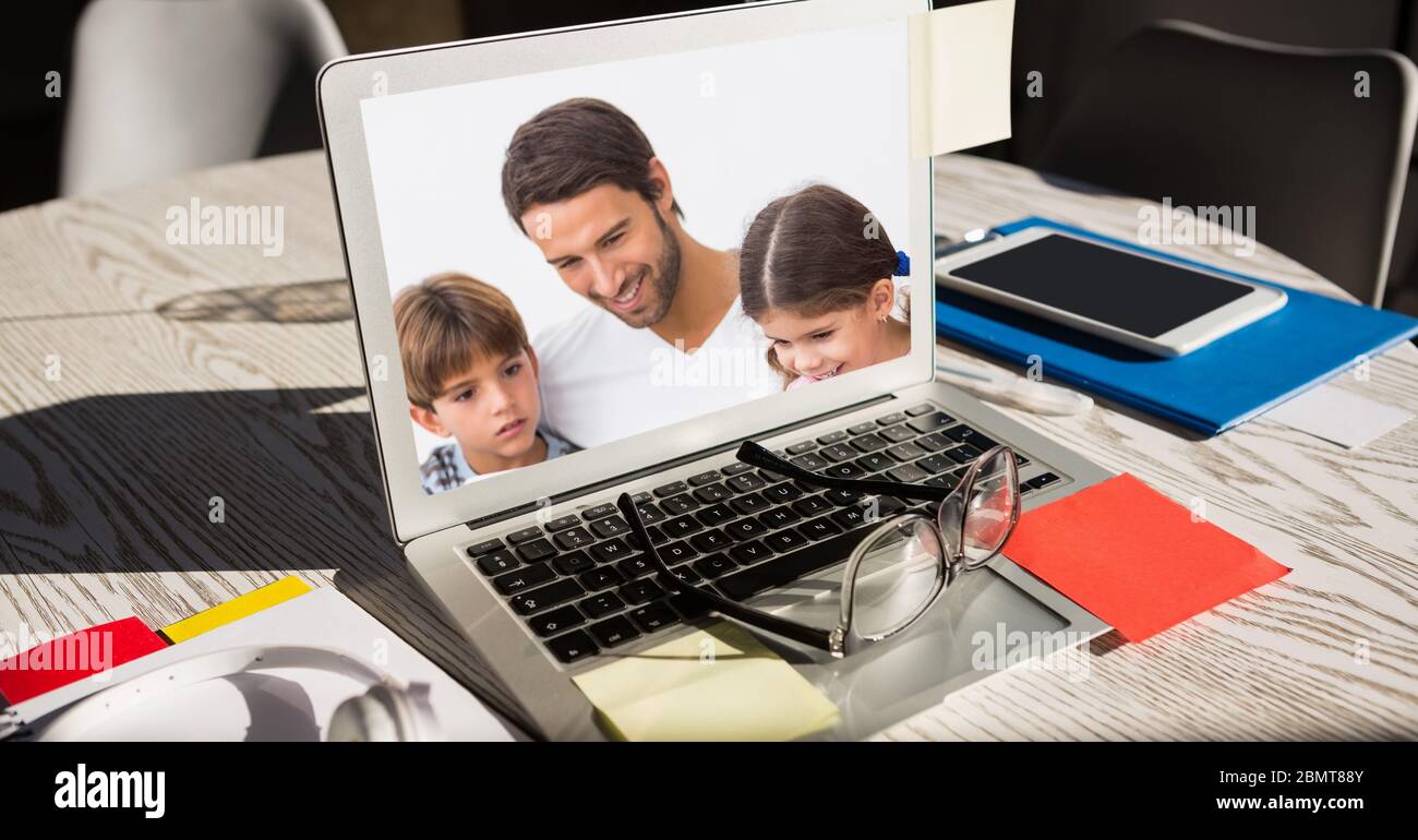 Homme avec deux enfants sur l'écran d'un ordinateur portable Banque D'Images
