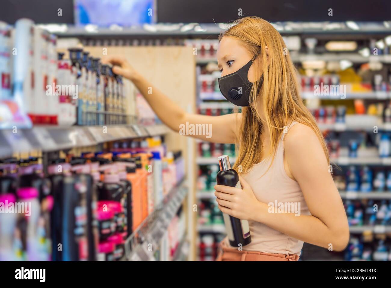 Une femme alarmée porte un masque médical contre le coronavirus lors de l'achat de produits chimiques domestiques dans les supermarchés ou les magasins, en santé, sécurité et pandémie Banque D'Images