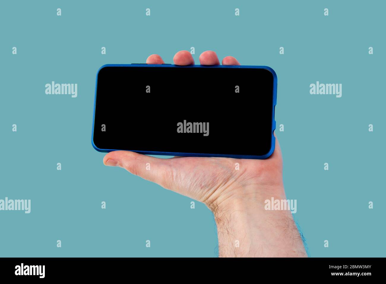 smartphone utilisé par l'homme sur fond bleu Banque D'Images