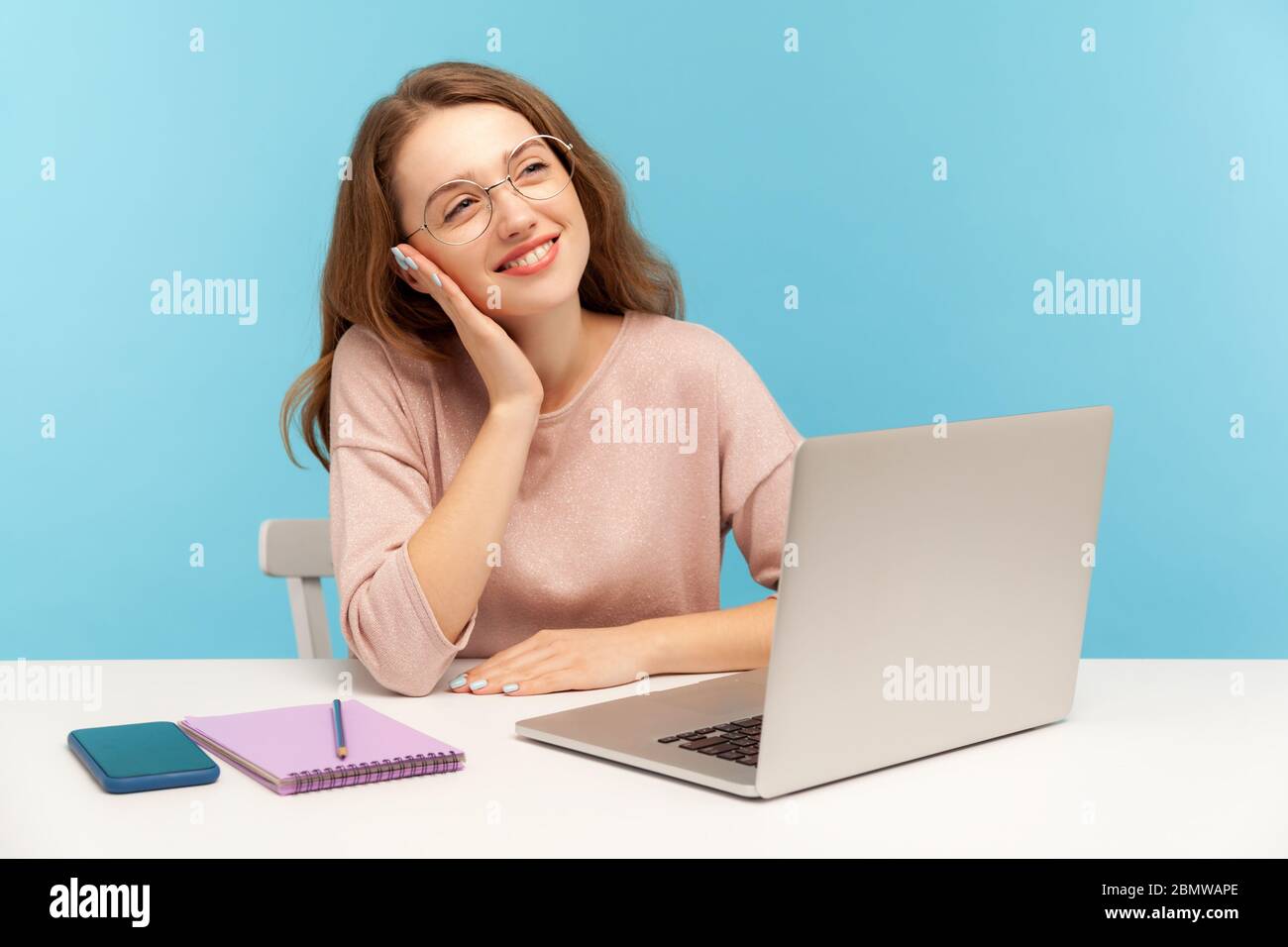 Femme heureuse et intelligente à lunettes rêvant de vacances, se reposant sur une pause, se détendant avec une expression méditative réfléchie, fantasisant et planifiant Banque D'Images