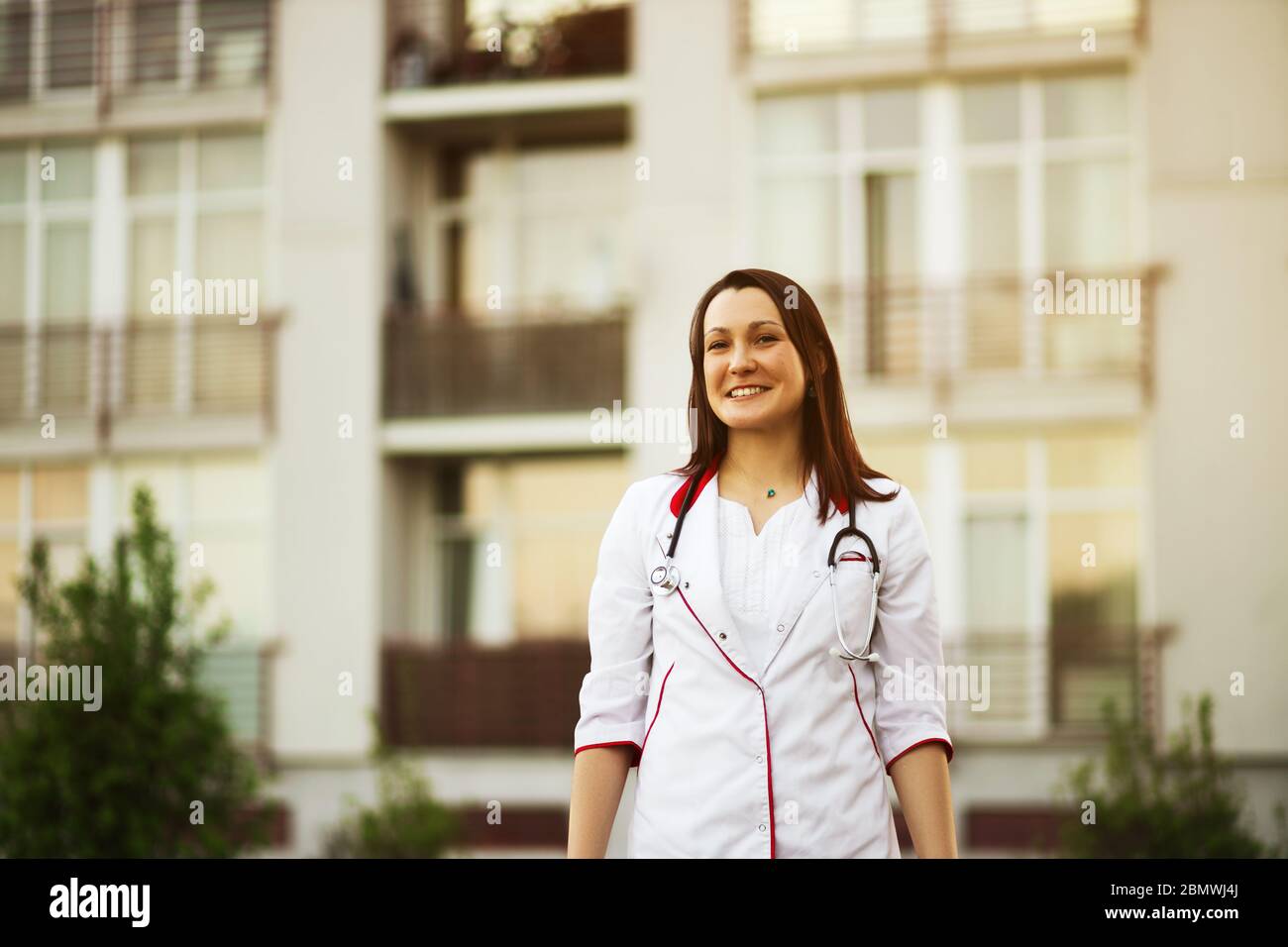 Une jeune femme médecin ou infirmière sourira à l'extérieur Banque D'Images