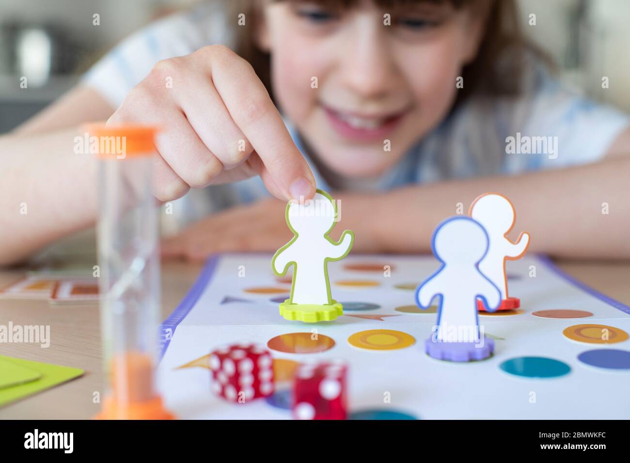 Fille souriante jouant à jeu de société générique à la maison Banque D'Images
