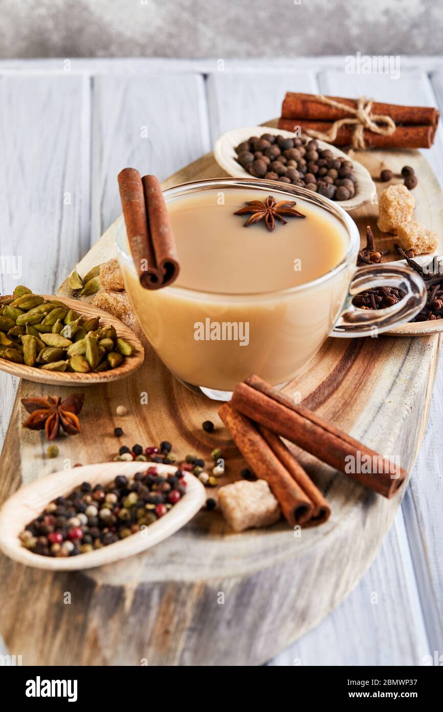 Boisson traditionnelle indienne - thé masala aux épices. Cannelle, cardamome, anis, sucre, clous de girofle, poivre sur fond de bois clair. Copier l'espace. Côté vie Banque D'Images