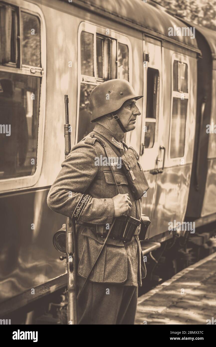 Vue sépia d'époque du soldat nazi en service à la gare ferroviaire du patrimoine, Severn Valley Railway, événement d'été des années 1940, Royaume-Uni. Banque D'Images