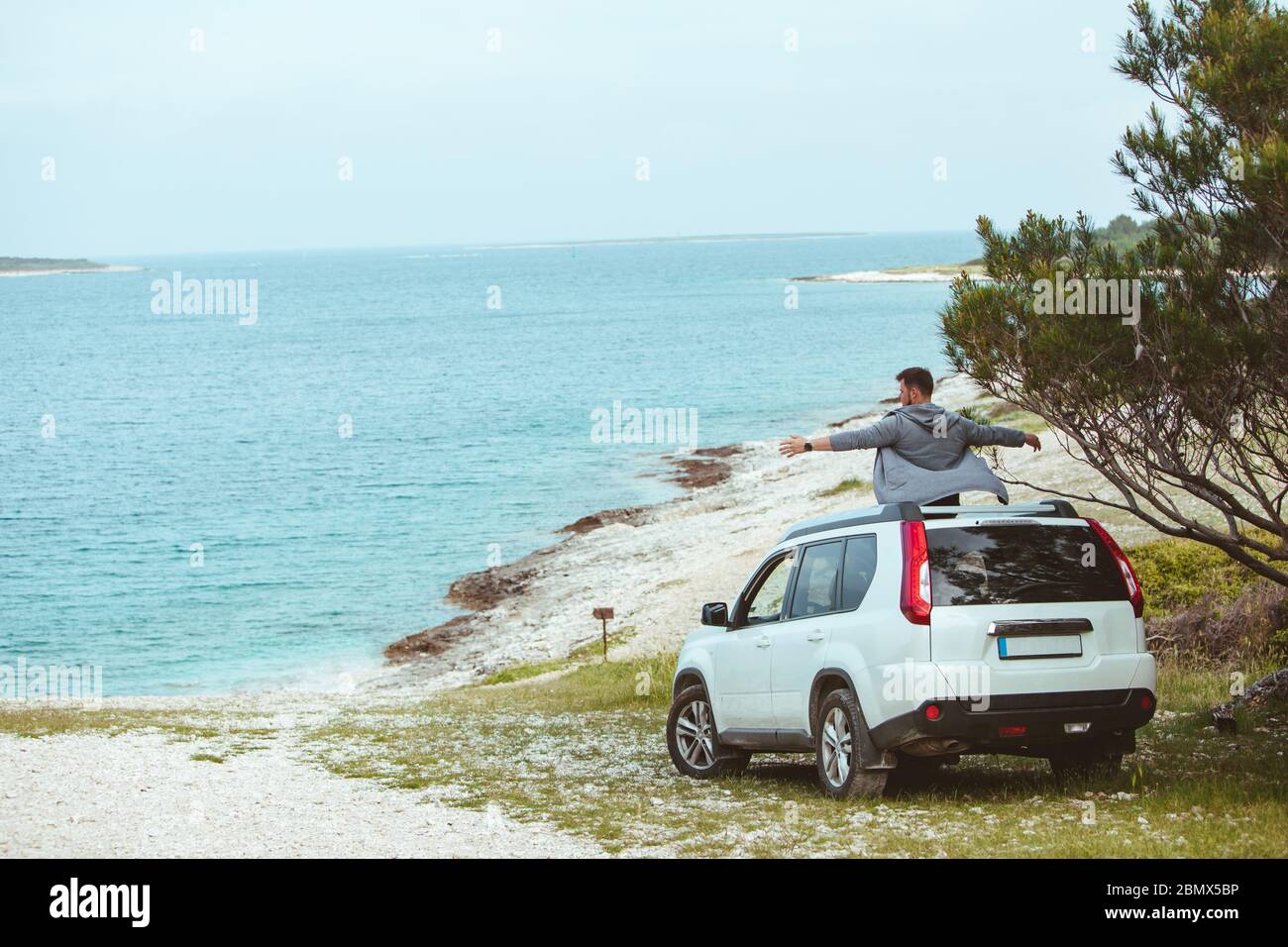 Heureux homme assis sur le toit d'une voiture Banque de photographies ...