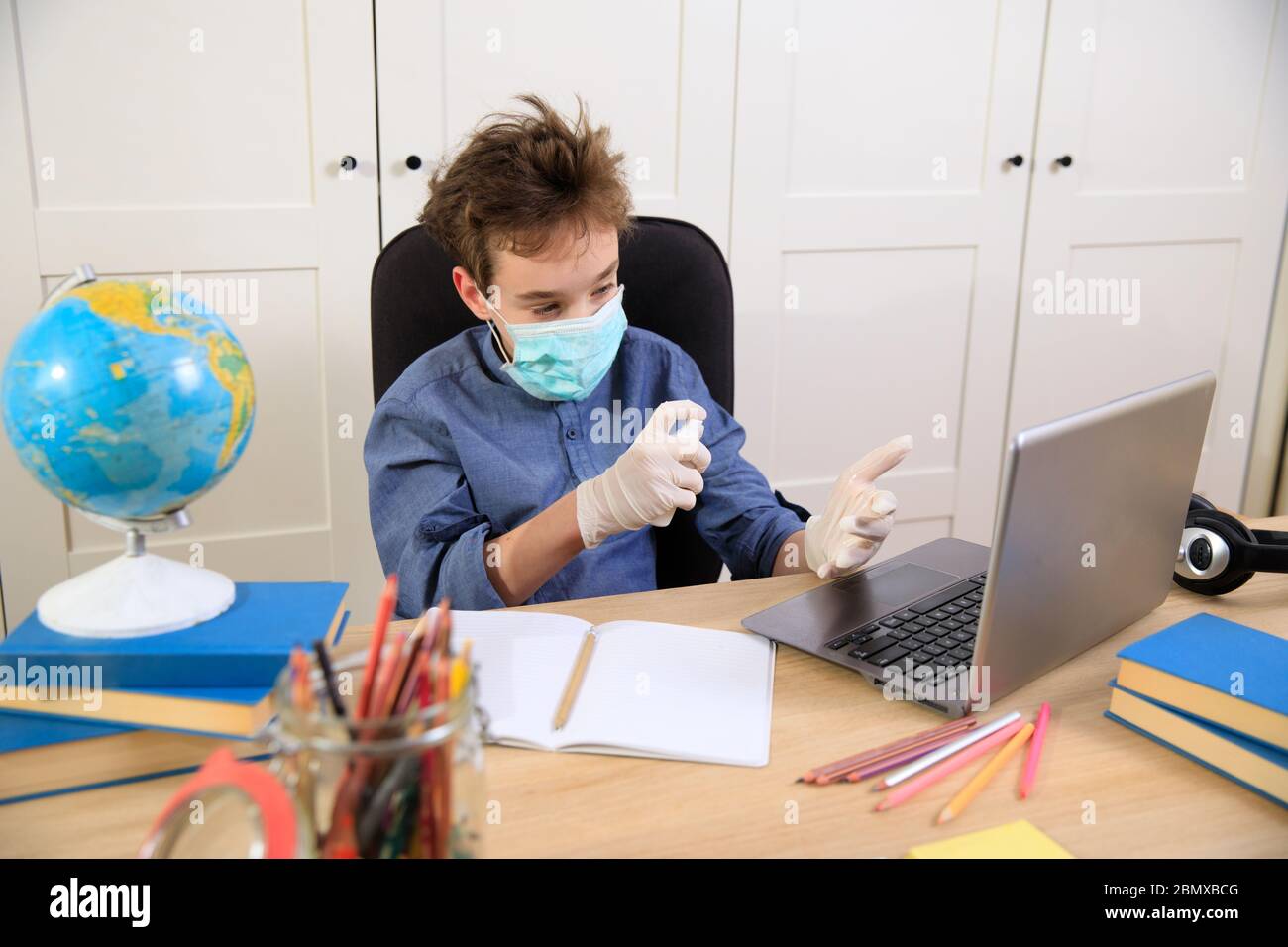 Enseignement en ligne à distance. Un garçon étudie à la maison et fait ses devoirs à l'école. Un apprentissage à distance à domicile , pandémie de coronavirus dans le Banque D'Images