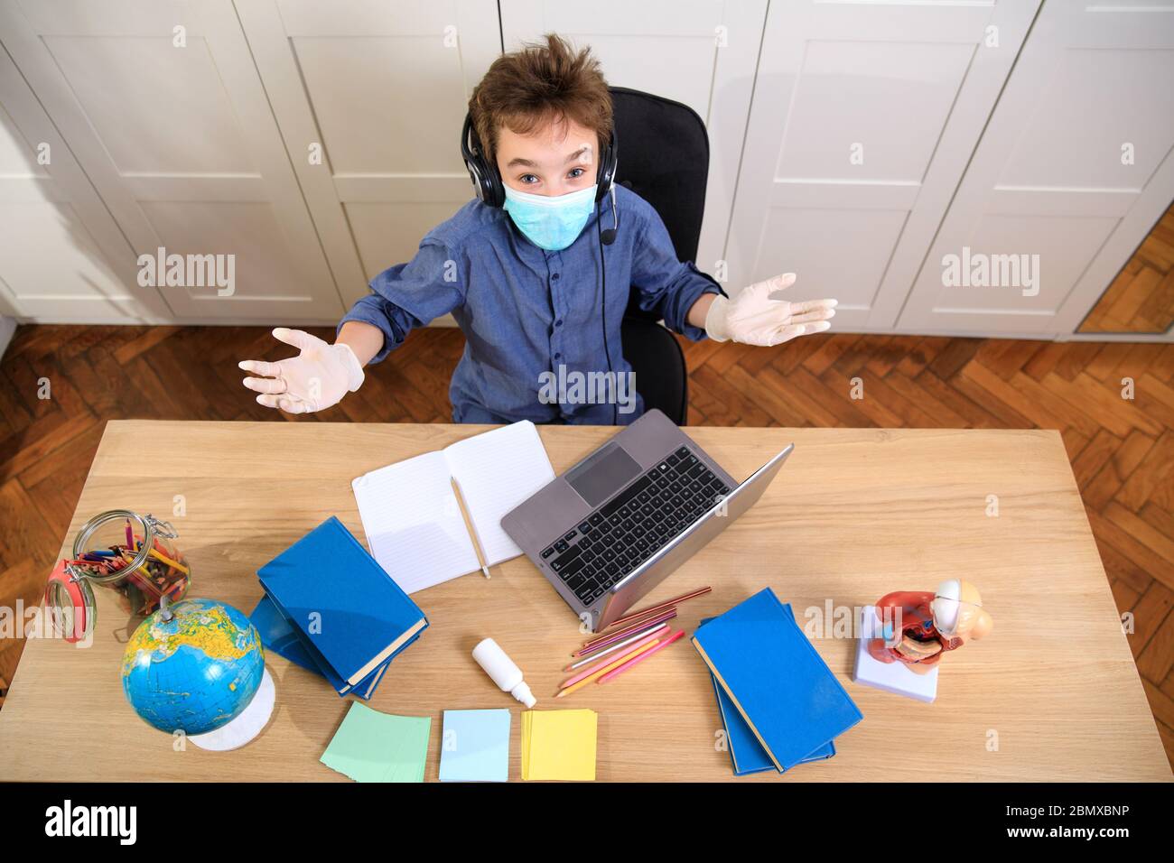 Enseignement en ligne à distance. Un garçon étudie à la maison et fait ses devoirs à l'école. Un apprentissage à distance à domicile , pandémie de coronavirus dans le Banque D'Images
