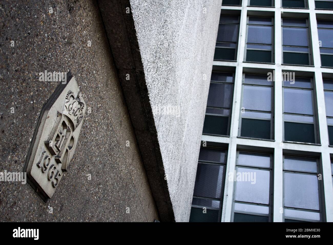 Une couronne royale « ER 1965 » ornant un immeuble de bureaux urbains gris. Banque D'Images