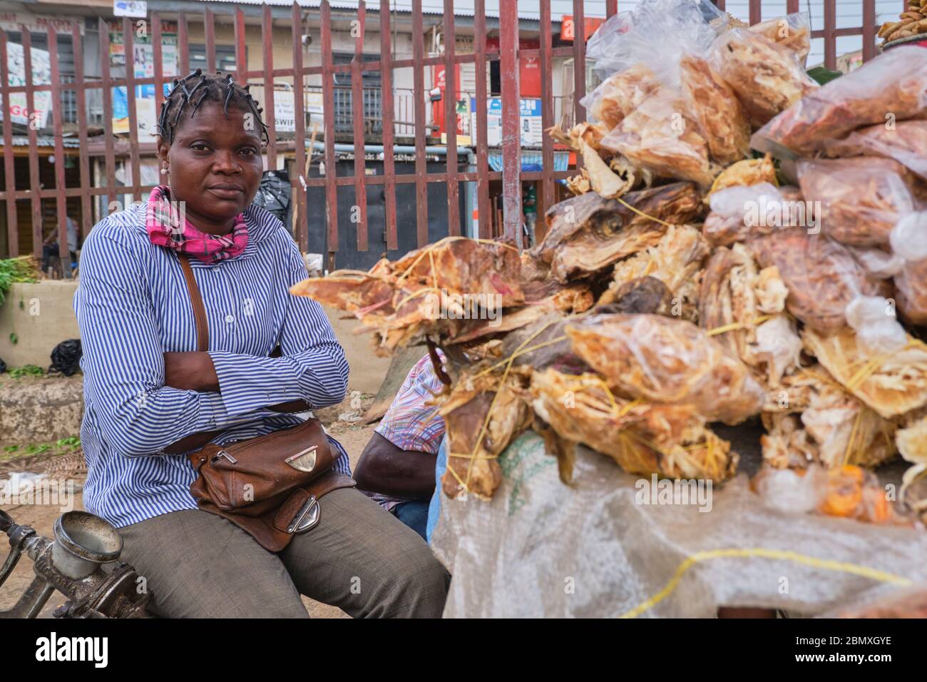 Portrait d'un négociant vendant du poisson de fond sur un marché de Lagos, au Nigeria. Banque D'Images