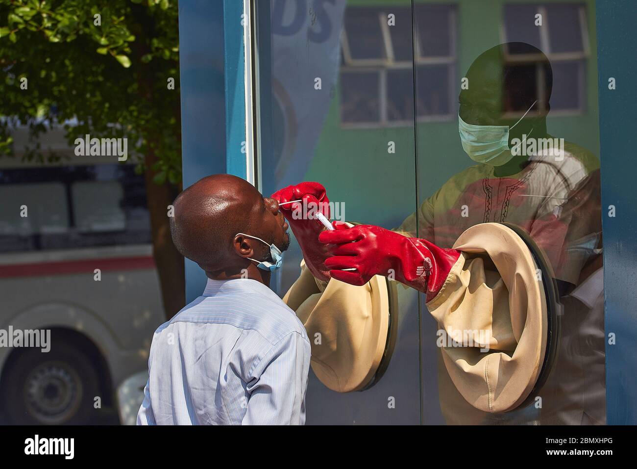 Un médecin prend un écouvillon d'un patient dans un centre de prélèvement d'échantillons de test Covid-19 de l'État d'Ogun, au Nigeria. Banque D'Images