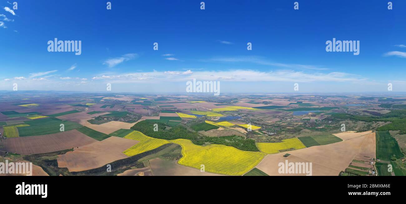 Vue aérienne du panorama rural de printemps : champs agricoles, forêt et villages. Paysage roumain Banque D'Images