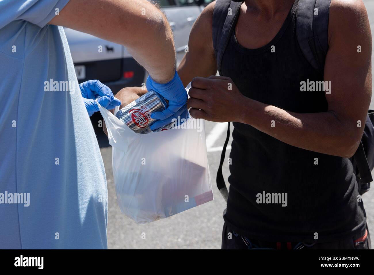 La Caleta, Costa Adeje, Tenerife, Iles Canaries. 11 mai 2020. L'organisme caritatif de la banque alimentaire El Arca de Noe, Noahs Ark, géré par des résidents britanniques, fournit de la nourriture, de l'eau et des boissons non alcoolisées à un groupe de personnes sans abri vivant en agitée le long de la côte de Costa Adeje. Ils comptent sur les dons des entreprises locales et distribuent des denrées alimentaires de base à plus de cent personnes trois fois par semaine. Banque D'Images