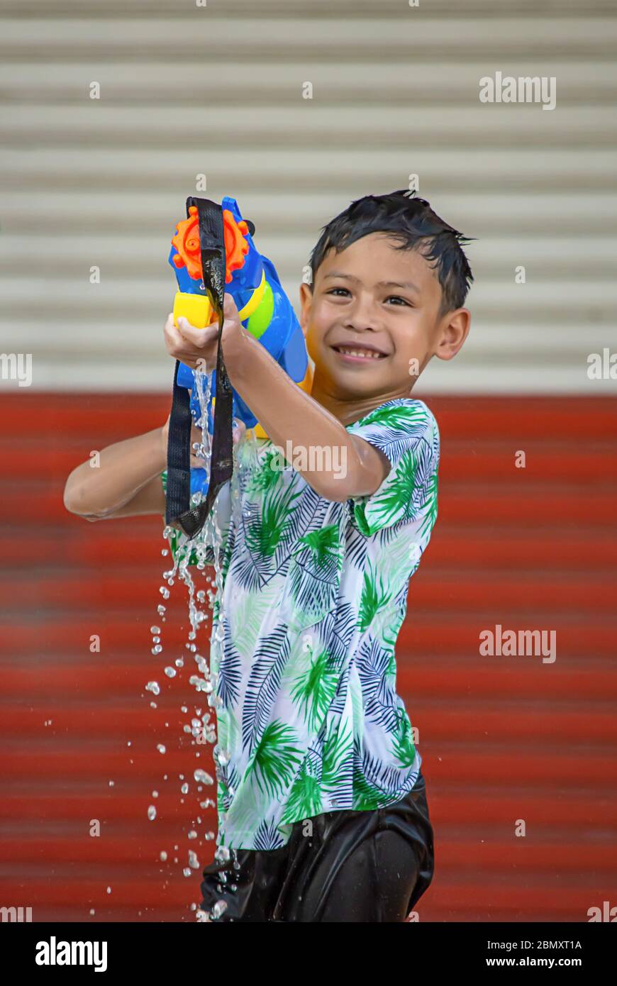 Asian boy holding a canon à eau jouer Songkran festival ou nouvel an Thaï en Thaïlande. Banque D'Images