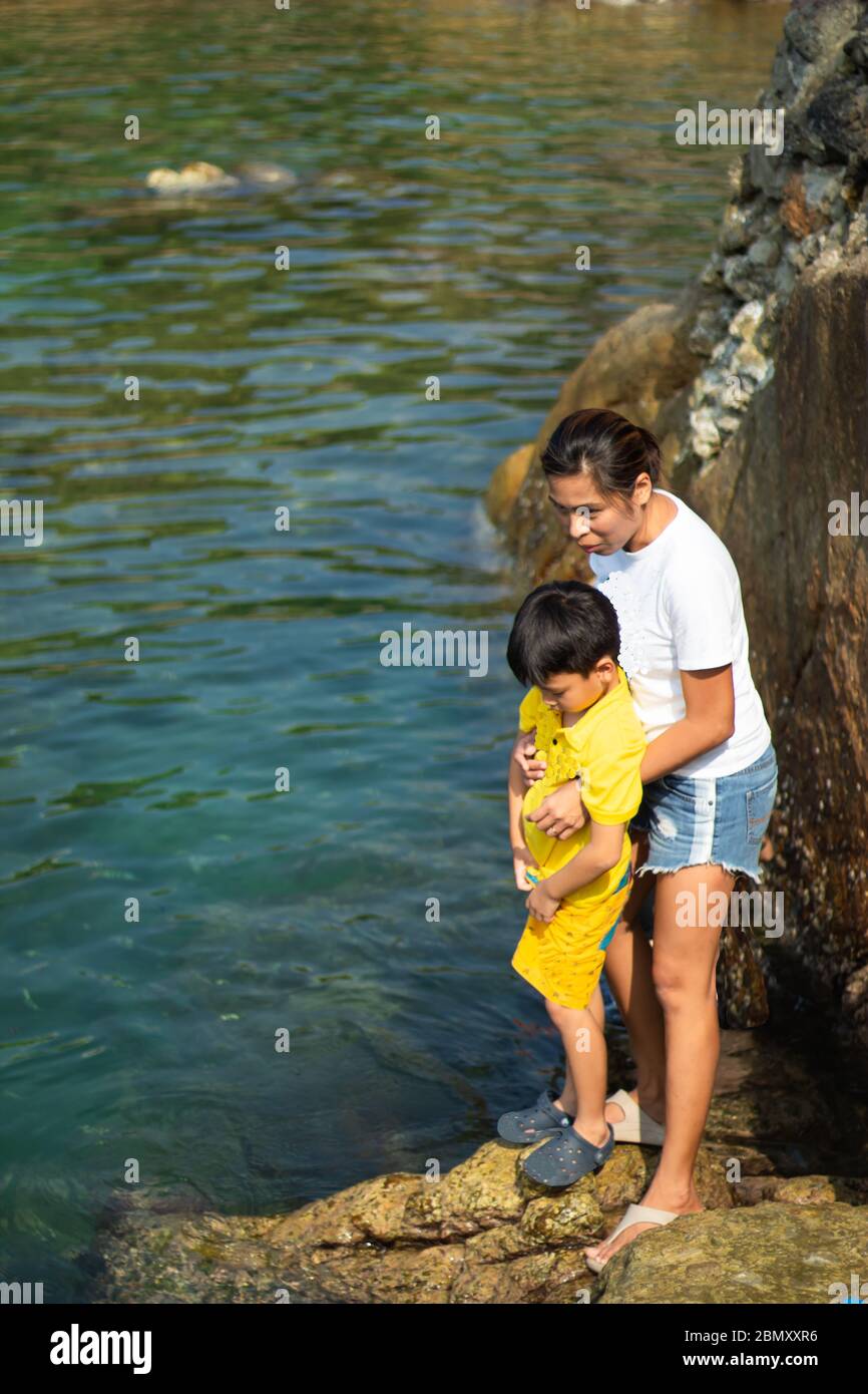 Mère et fils regardant le poisson dans la mer. Banque D'Images