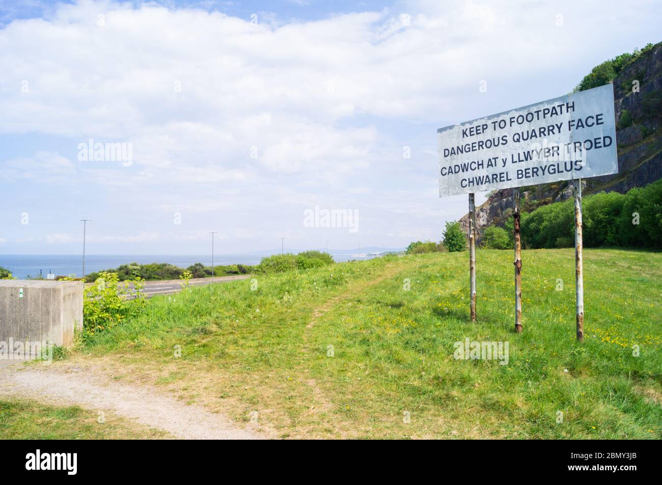 Panneau à Rainbow Bridge, pays de Galles indiquant « Keep to Footpath dangereuse carrière face » en gallois « cadwch at y llwybr troed chwarel beryglus » Banque D'Images