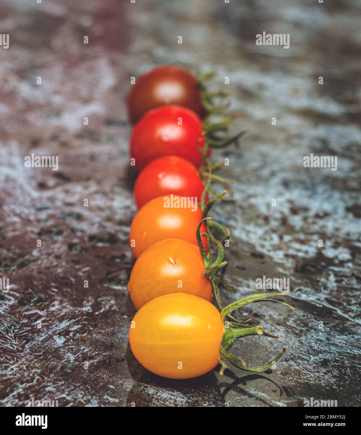 Ligne parfaite gradation de couleur de diverses sortes de tomates sur la table Banque D'Images