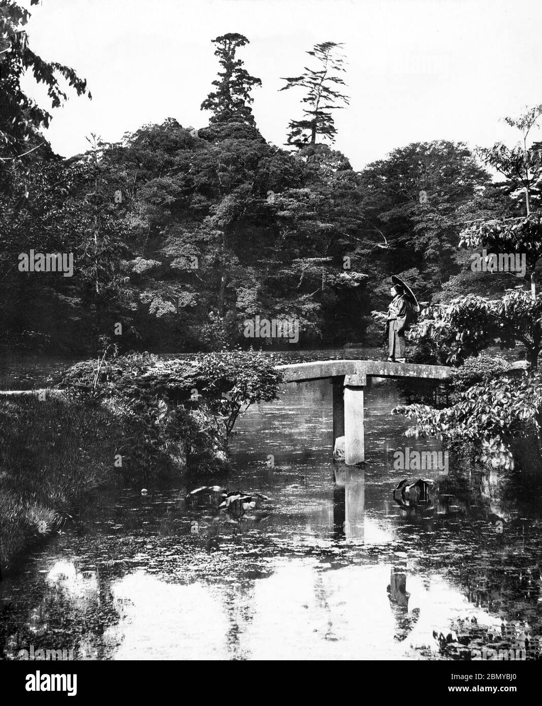 [ 1890 Japon - jardin japonais ] — Pont de pierre à Korakuen (後楽園), le jardin de l'ancien Mito Yashiki (旧水戸邸) à Bunkyo-ku, Tokyo. Le jardin a été commencé par Tokugawa Yoridusa (徳川頼房, 1603–1661) en 1629, et complété par son fils Tokugawa Mitsukuni (徳川光圀, 1628–1701). Il intègre des éléments chinois et japonais. C'est l'un des trois jardins daimyo (seigneur féodal) survivants à Tokyo. diapositive en verre vintage du xixe siècle. Banque D'Images