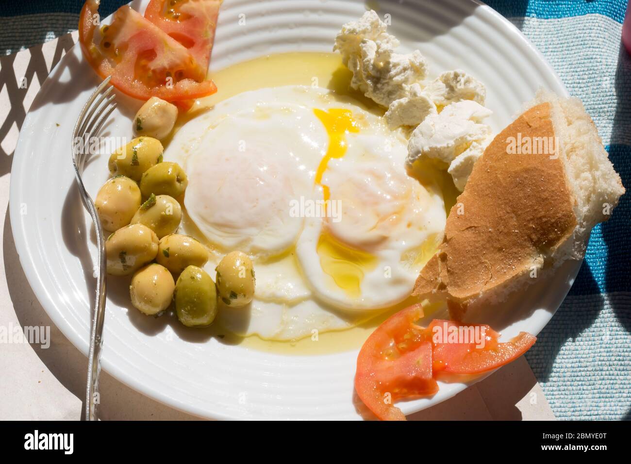 Œufs cuits pochés au fromage de chèvre, tomates et olives, petit déjeuner marocain Banque D'Images