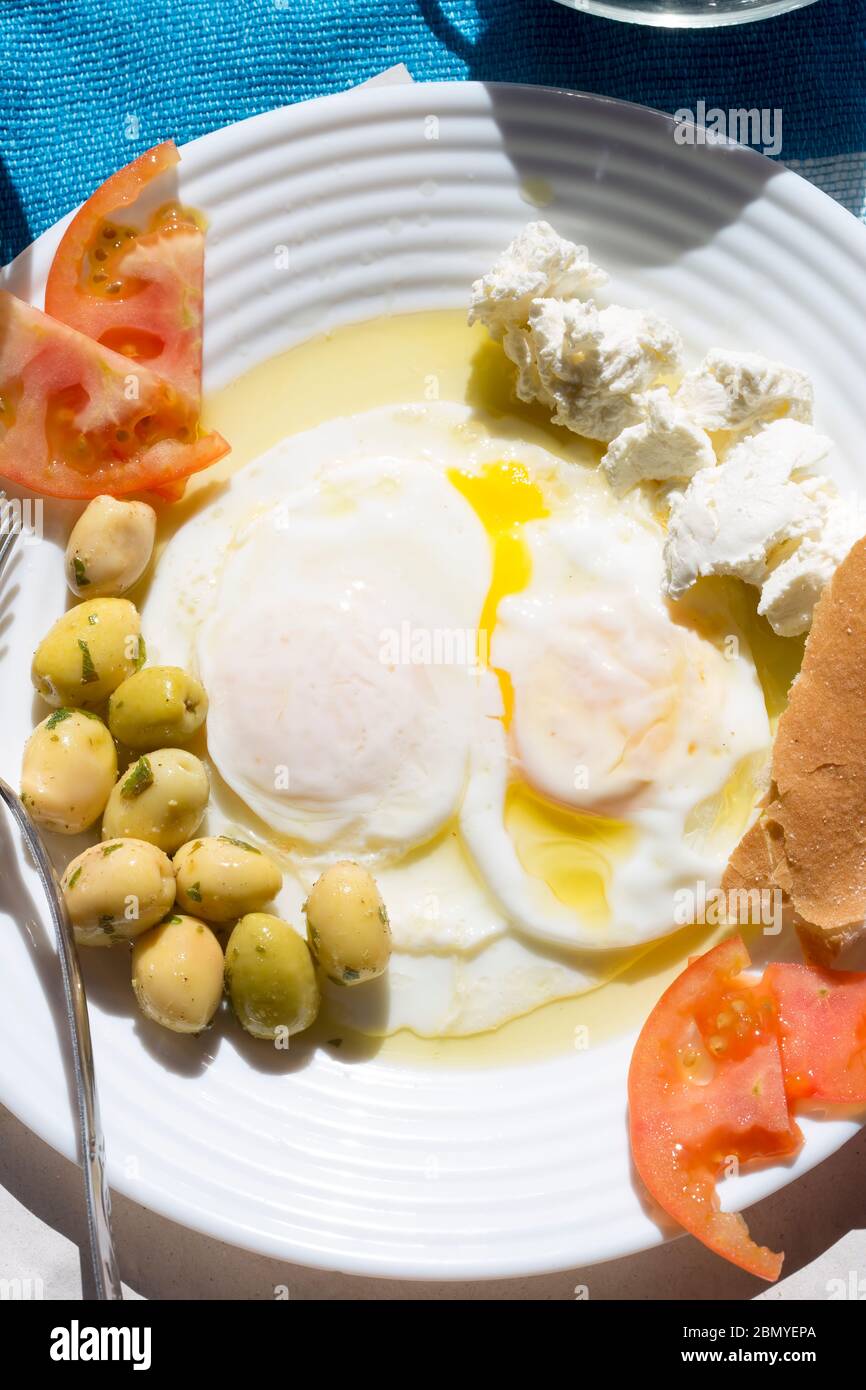 Œufs cuits pochés au fromage de chèvre, tomates et olives, petit déjeuner marocain Banque D'Images