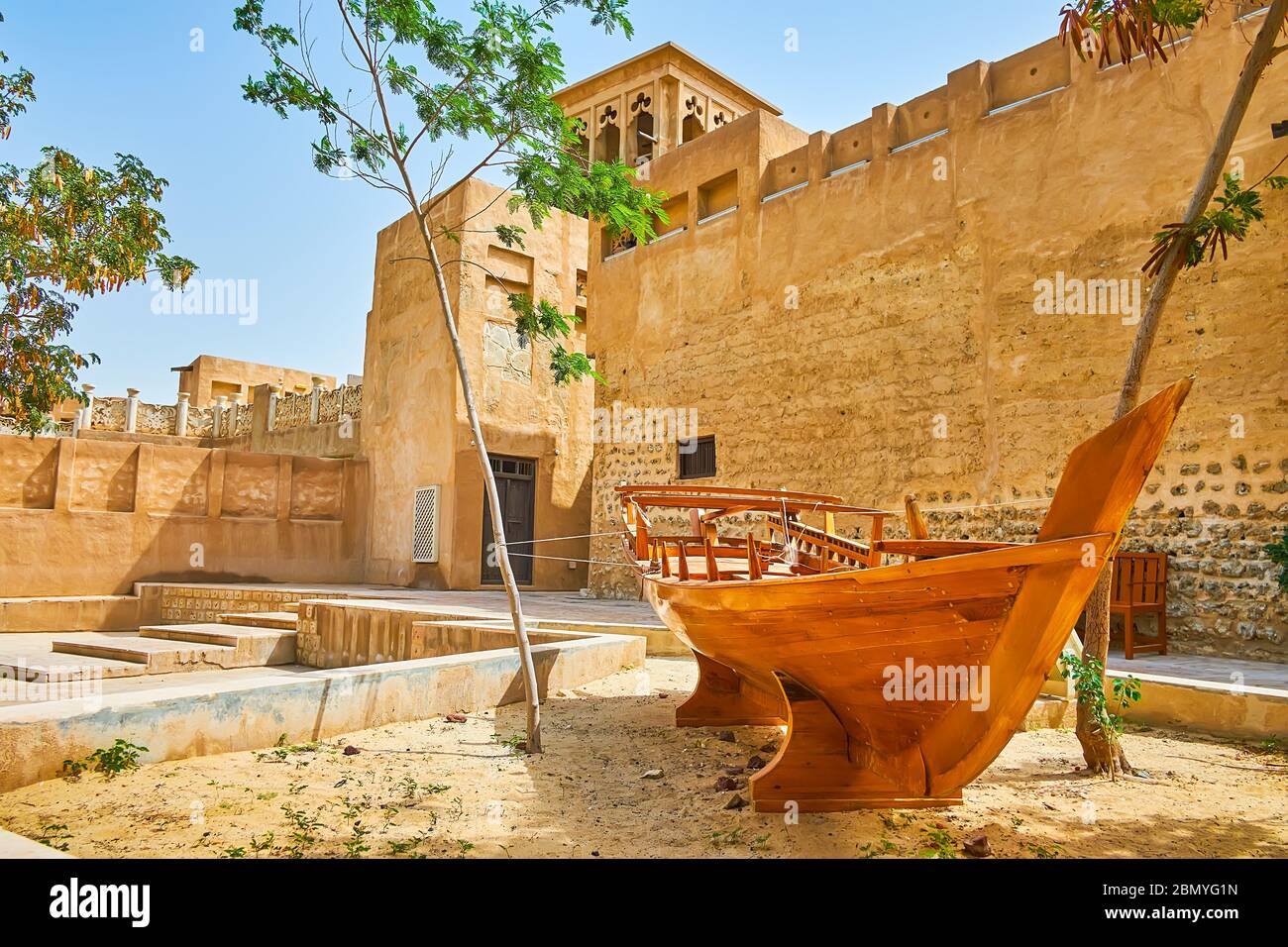 La vieille rue en argile avec un logement authentique est décorée avec un bateau de pêche traditionnel, Al Bastakiya (Al Fahidi), Dubaï, eau Banque D'Images
