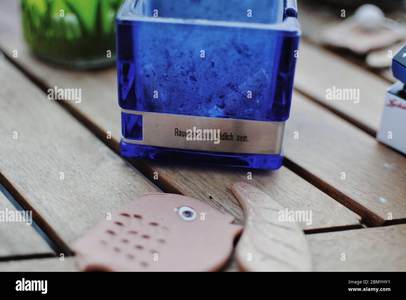 'Moking tues' en allemand écrit sur le cendrier et les poissons en céramique cassés Banque D'Images
