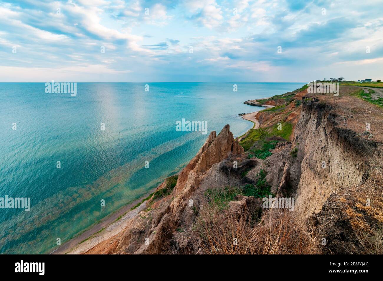 Côte de mer pittoresque avec falaises de sable colorées et ciel de coucher de soleil Banque D'Images