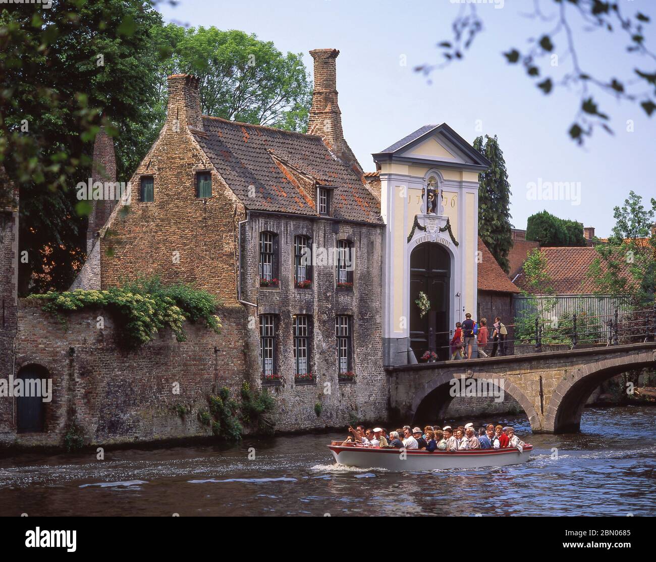 Bateau-canal touristique passant par le Béguinage (Begijnhuiseje), Bruges (Brugge), province de Flandre Occidentale, Royaume de Belgique. Banque D'Images