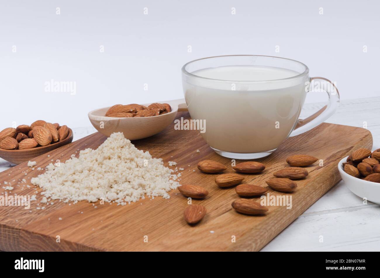 Lait d'amandes en tasse avec farine d'amandes et noix d'amandes sur fond en bois Banque D'Images
