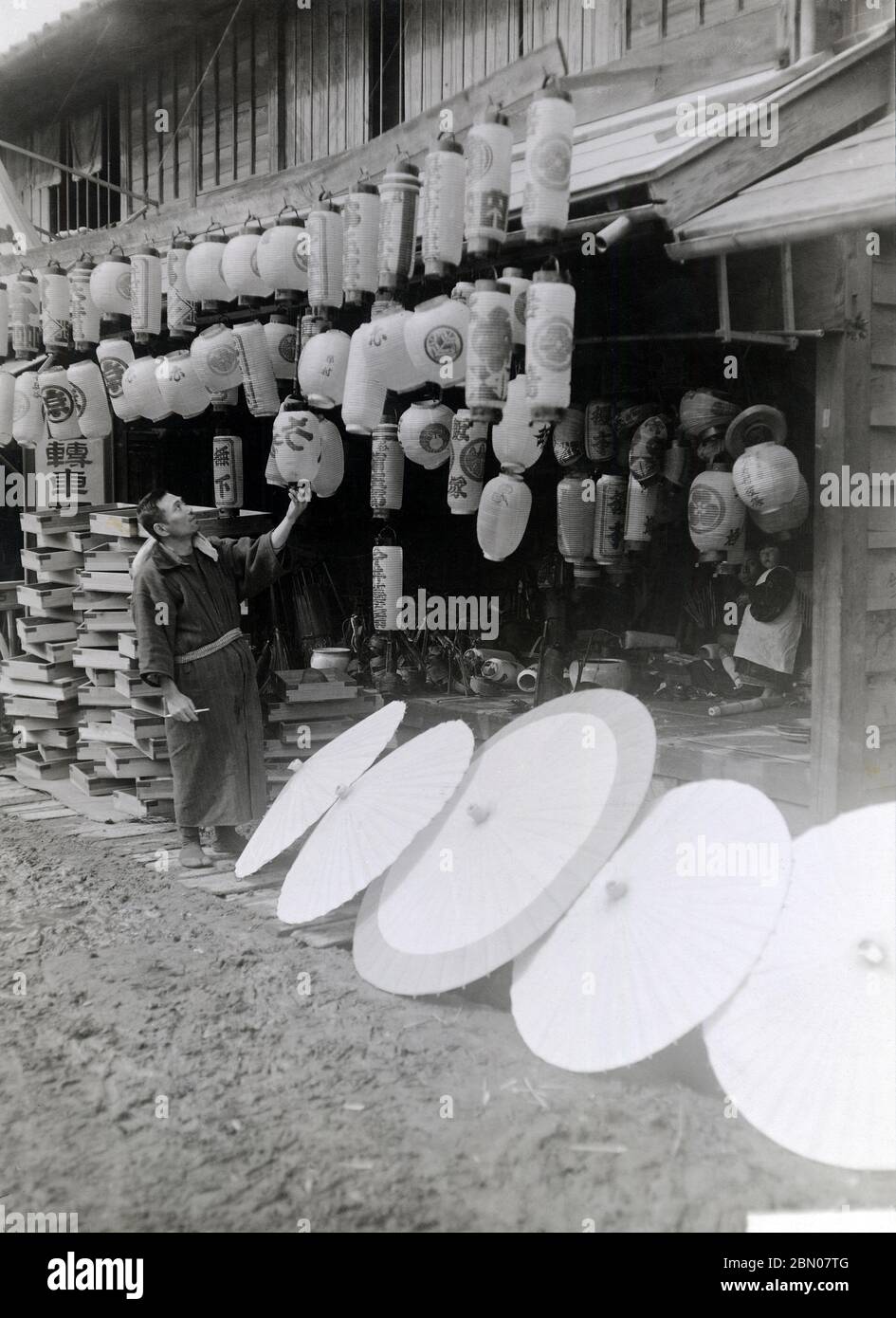[ années 1920 Japon - Lanterne et parasol japonais ] — Boutique vendant lanternes et parasols en papier. Comme les deux étaient en papier, ils étaient habituellement produits dans le même atelier. imprimé gélatine argent du xxe siècle. Banque D'Images