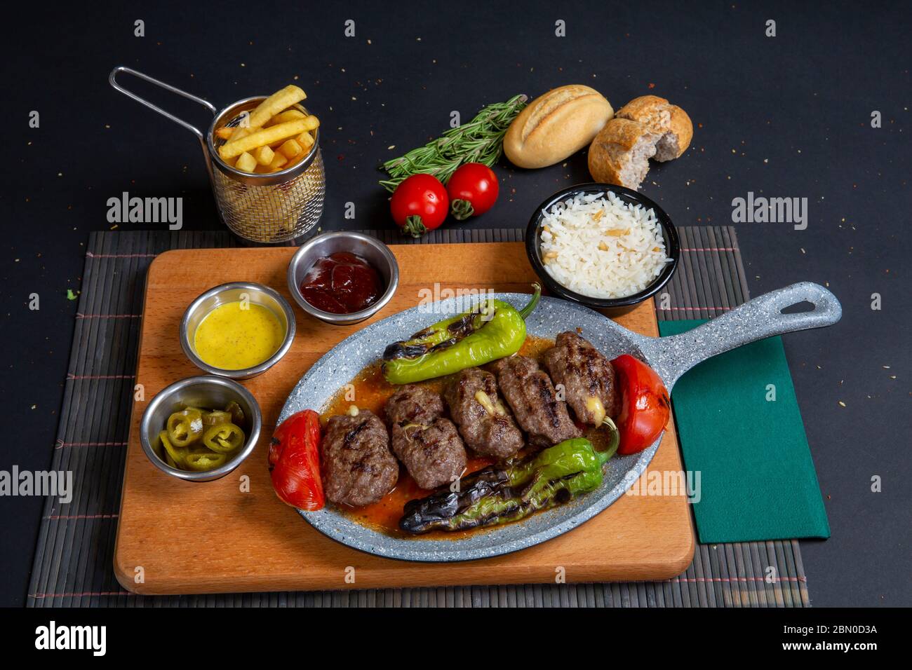 Boulettes de bœuf rôties faites maison dans une poêle en fonte sur une table en bois dans la cuisine, persil frais, fourchette vintage Banque D'Images