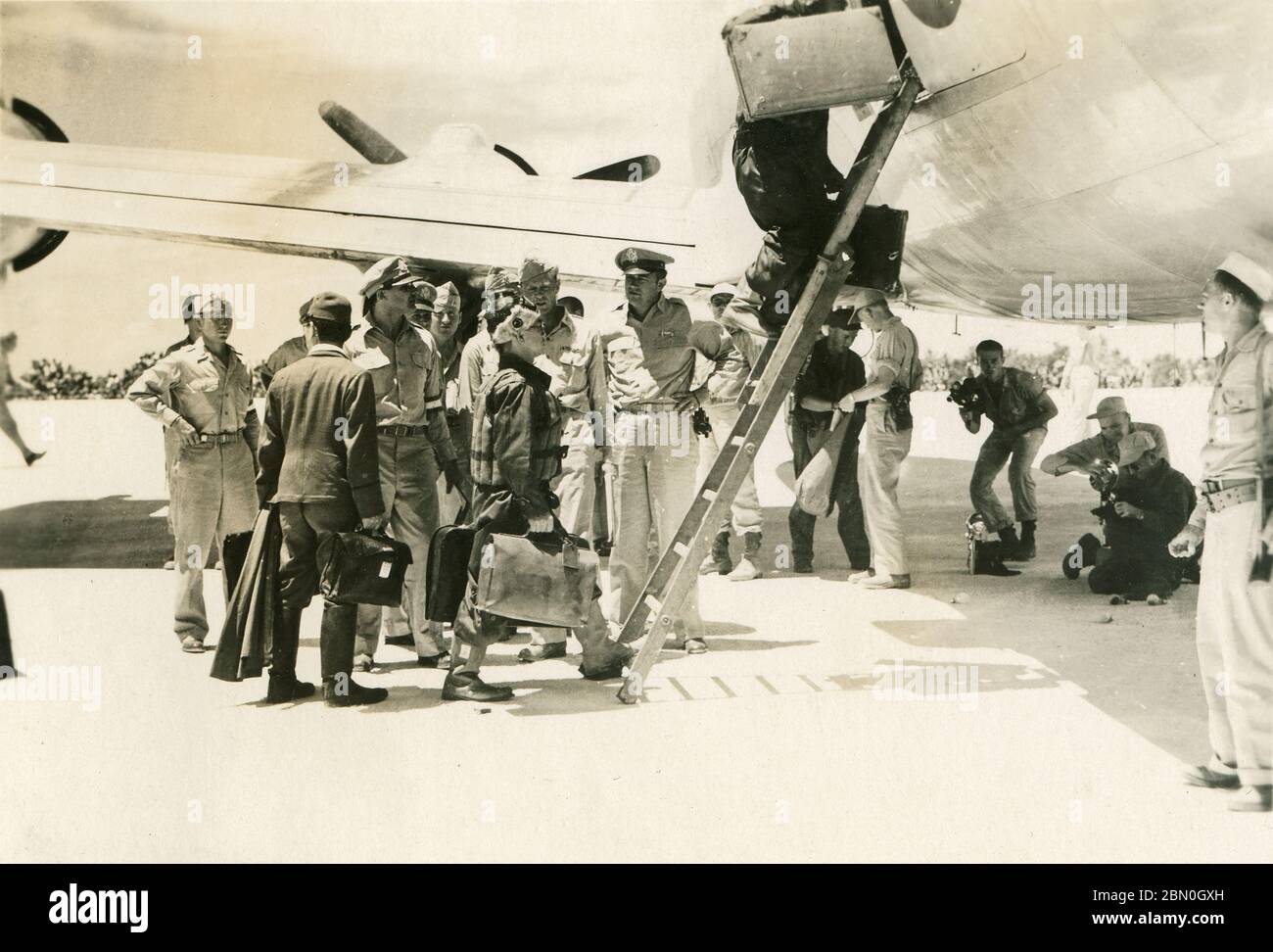 [ 1945 Japon - les Japonais abanquent la Seconde Guerre mondiale ] — des émissaires japonais embarquent à bord d'un avion de transport Skymaster C-54 américain sur l'île d'Iejima, tenue aux États-Unis, dans la préfecture d'Okinawa, peu après midi, le 19 août 1945 (Showa 20). L'avion les a conduits à Manille pour rencontrer le personnel du général Douglas MacArthur afin de définir les détails de la capitulation du Japon marquant la fin de la Seconde Guerre mondiale. Peu de temps auparavant, la délégation était arrivée sur des bombardiers japonais Mitsubishi G4M 'Betty' spécialement marqués. imprimé gélatine argent du xxe siècle. Banque D'Images