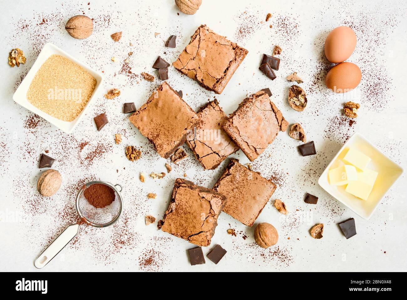 Vue de dessus du gâteau au brownie fraîchement préparé maison, préparé avec des ingrédients de recette sur fond rustique blanc. Banque D'Images