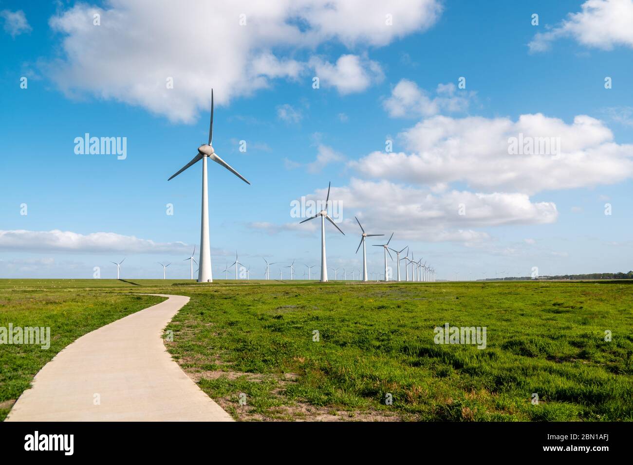 Chemin par la digue à l'immense parc de moulin à vent avec d'énormes éoliennes aux pays-Bas Noordoosstpolder, parc de moulin à vent d'énergie verte à Flevoland Banque D'Images