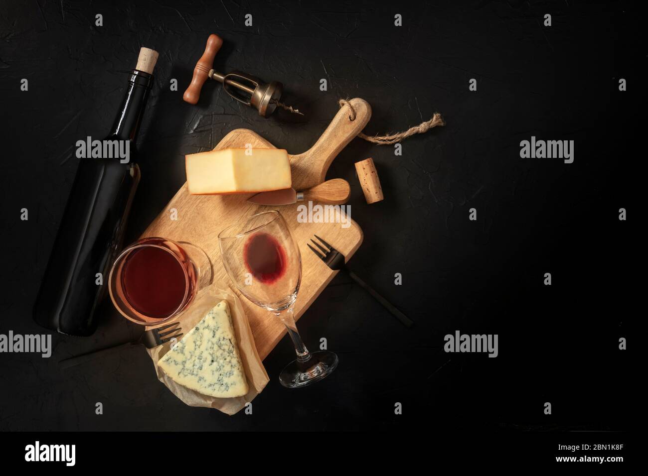 Dégustation de vin et de fromage, photo de haut sur fond noir avec un lieu pour le texte, avec un liège, un tire-bouchon et une bouteille Banque D'Images