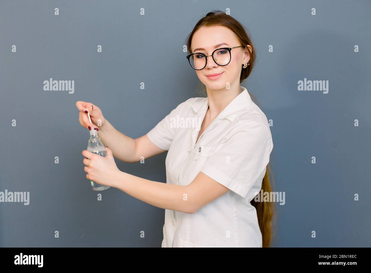 belle femme médecin cosmetologiste tenant la seringue et bootle avec solution pour les injections de beauté. isolé femme studio portrait. Banque D'Images