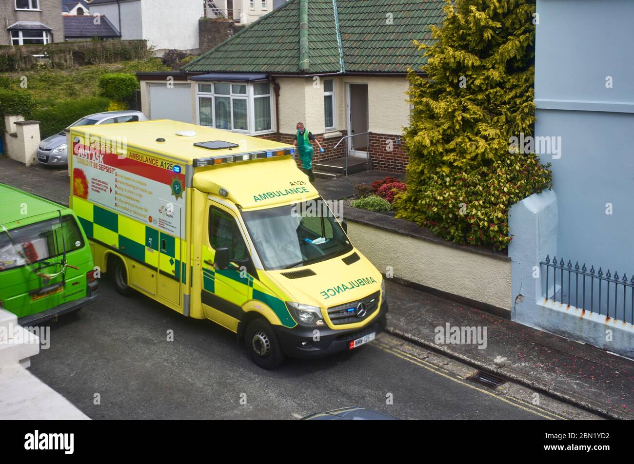 L'ambulance de l'île de Man à l'extérieur d'un bungalow avec l'opérative sortant porter Covid-19 porter pendant les tests à domicile de personnes âgées Banque D'Images
