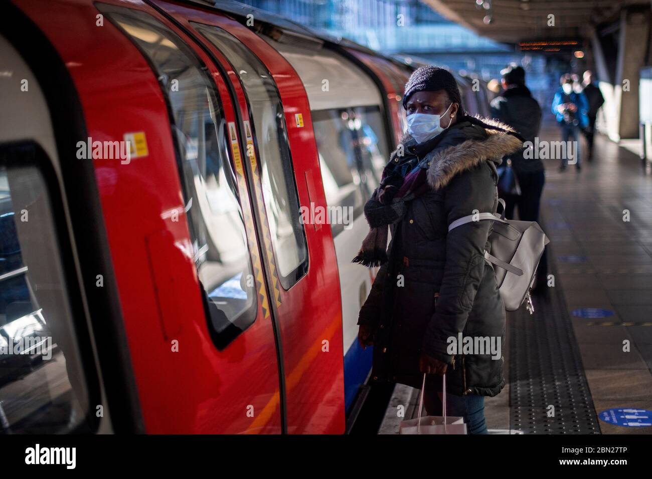 Les passagers portent des masques sur une plate-forme à la station de métro Canning Town de Londres. Banque D'Images