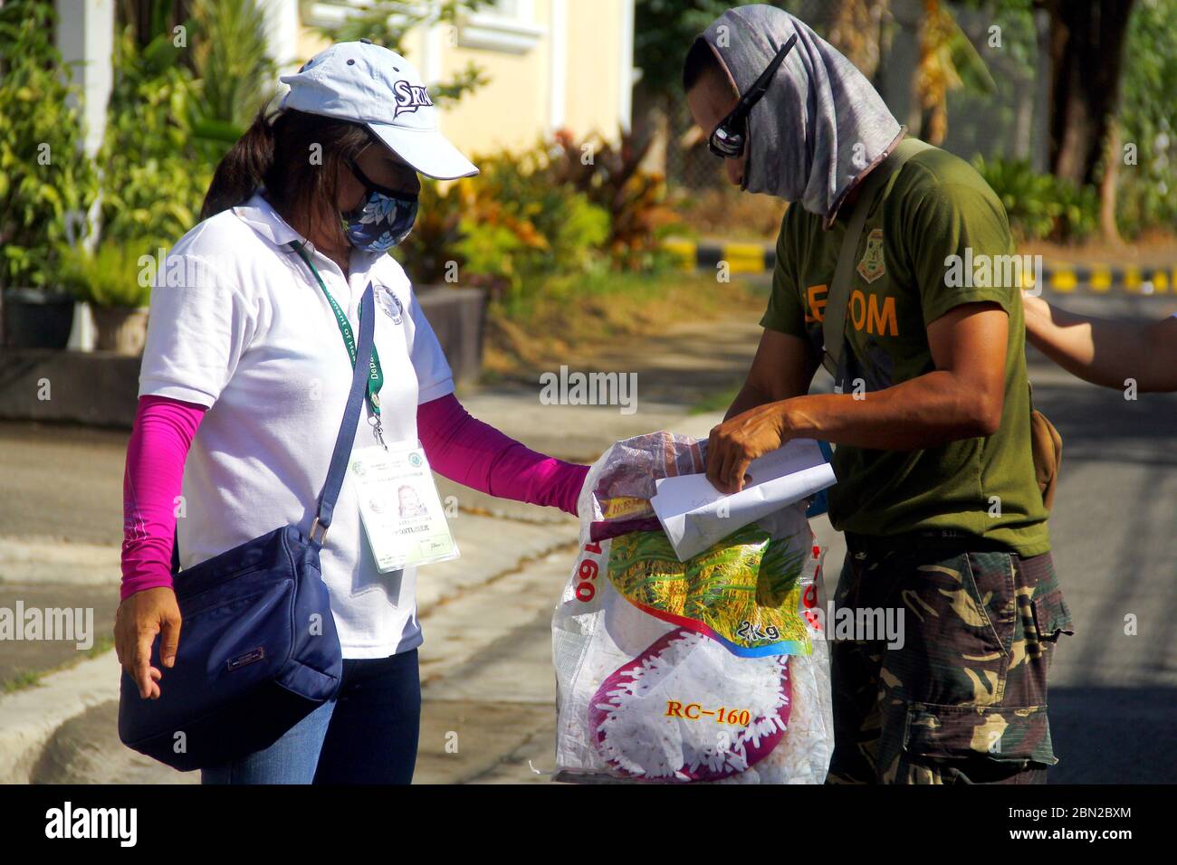 Antipolo City, Philippines - 11 mai 2020 : les agents des administrations locales et les membres de la police nationale distribuent des secours aux résidents pendant le Banque D'Images