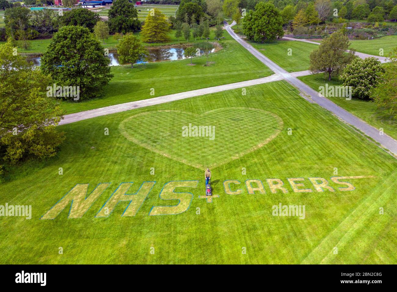 Nigel Downs, horticulteur de machines et de gazon, met la touche finale à un message de remerciement pour le personnel du NHS et les soignants du RHS Hyde Hall Gardens à Chelmsford, Essex. Banque D'Images