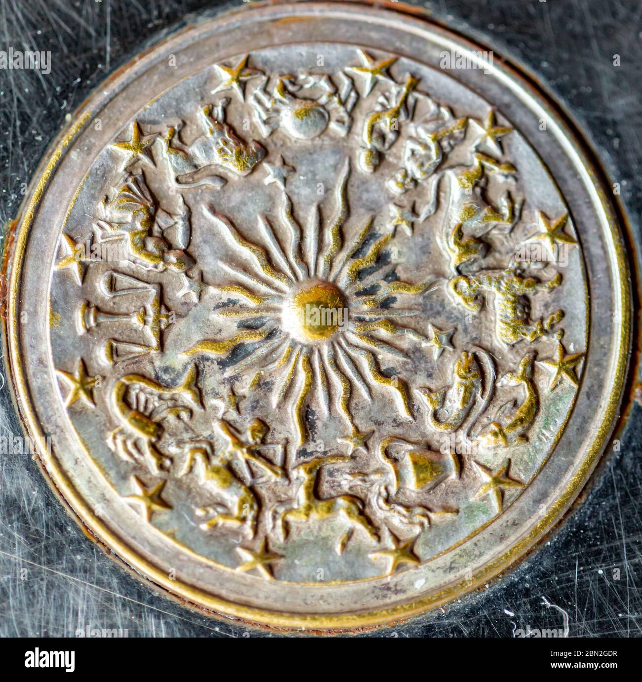 emblème métallique rond d'un zodiaque avec soleil au milieu Banque D'Images