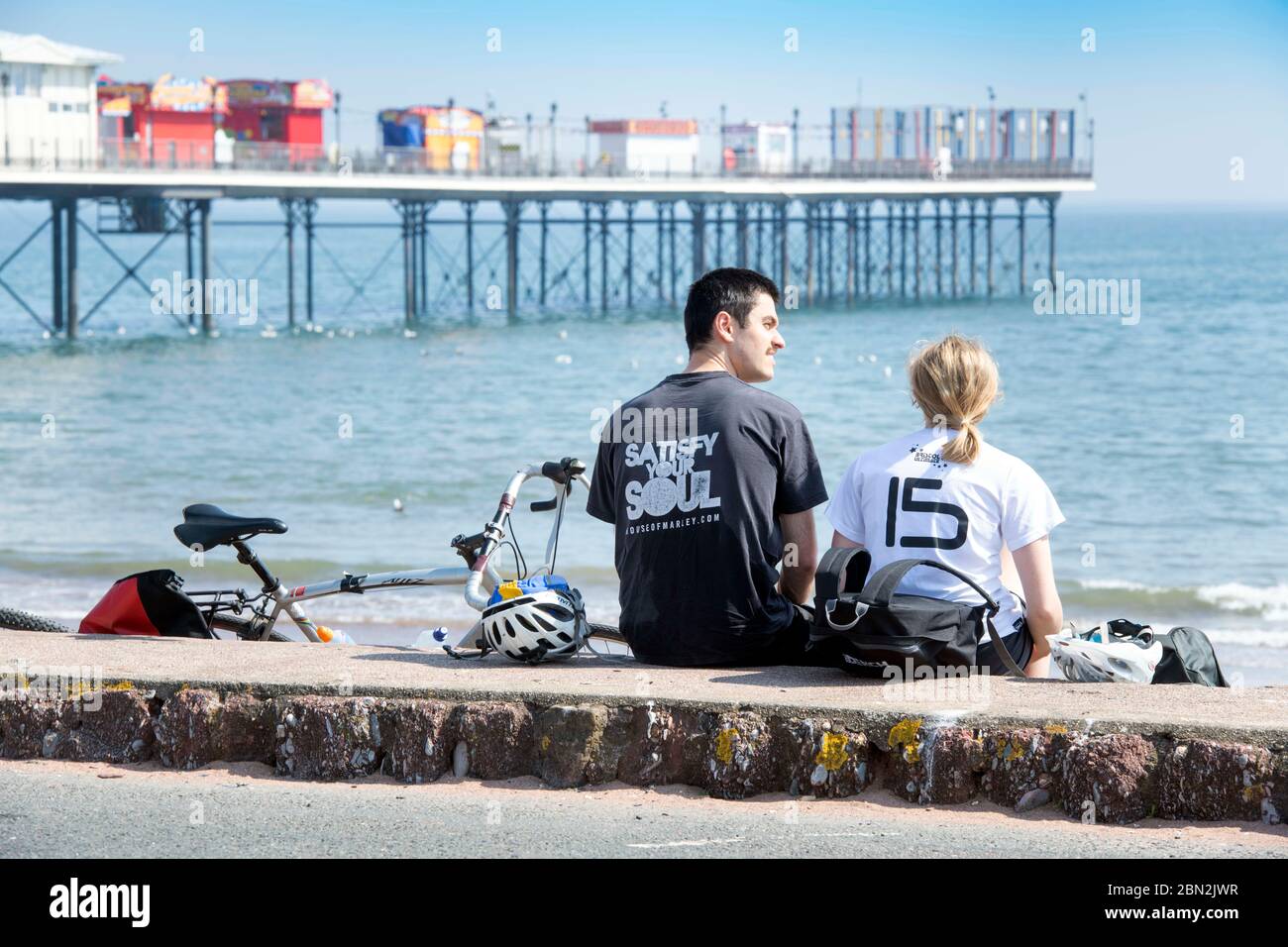 Une pause en couple après le vélo sur le front de mer à Paignton, Royaume-Uni Banque D'Images