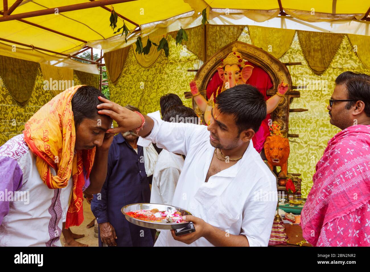 Orcha, Madhya Pradesh, Inde : UN prêtre à un temple de fortune place une marque de tilaka sur le front d'un dévot . Banque D'Images