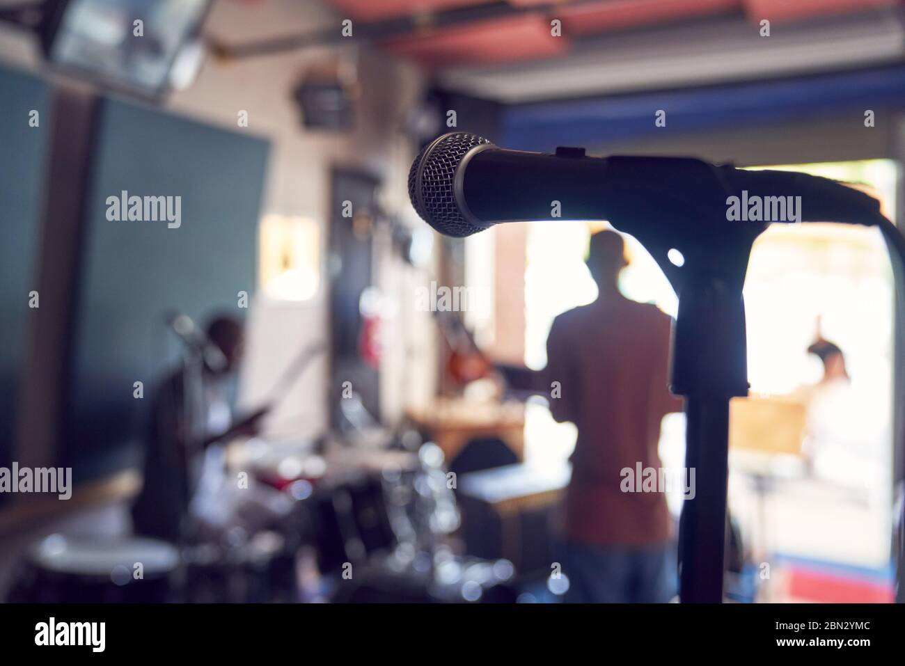 Microphone et musiciens dans le studio d'enregistrement en garage Banque D'Images