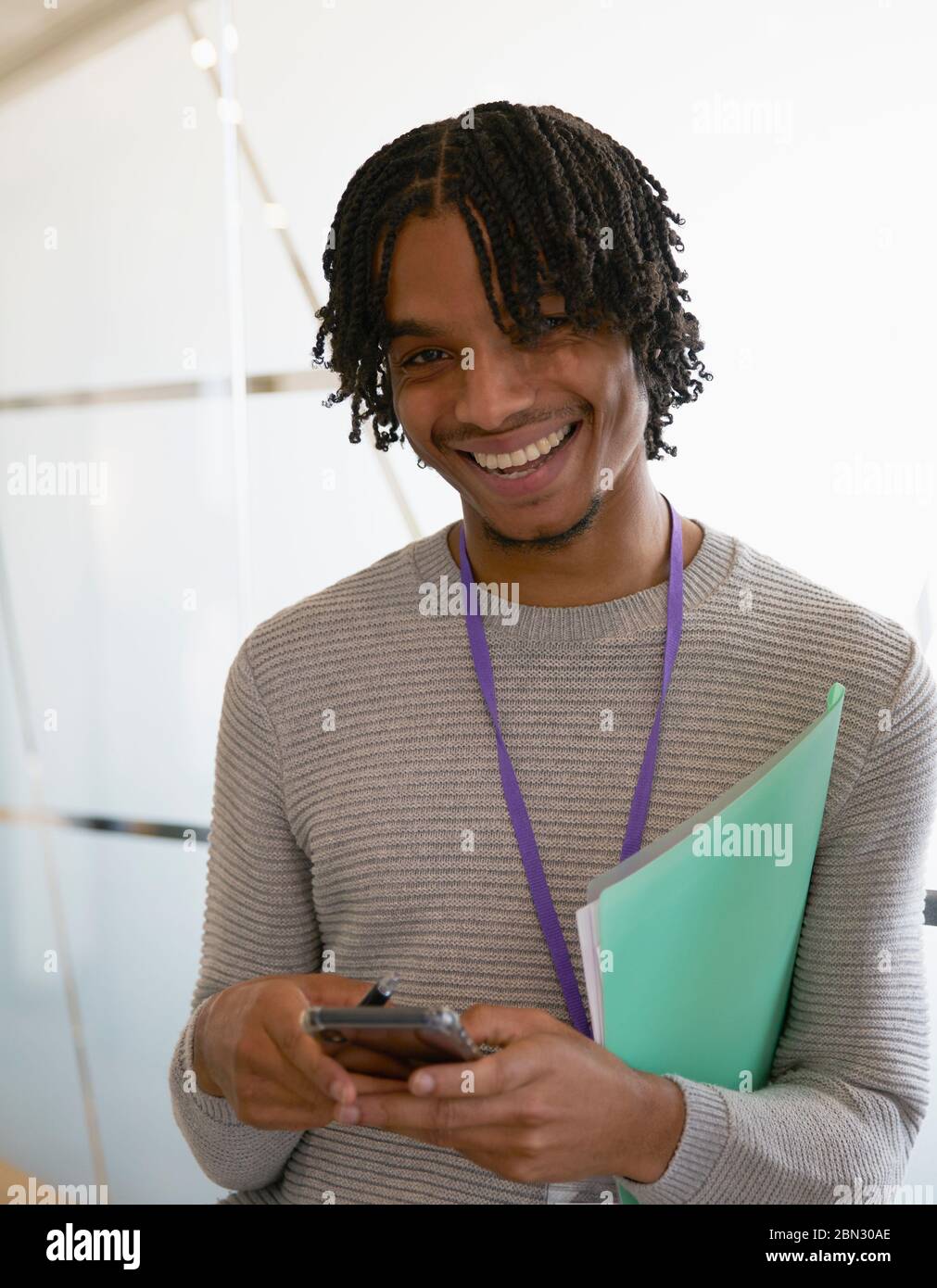 Portrait Happy businessman textant avec smartphone au bureau Banque D'Images