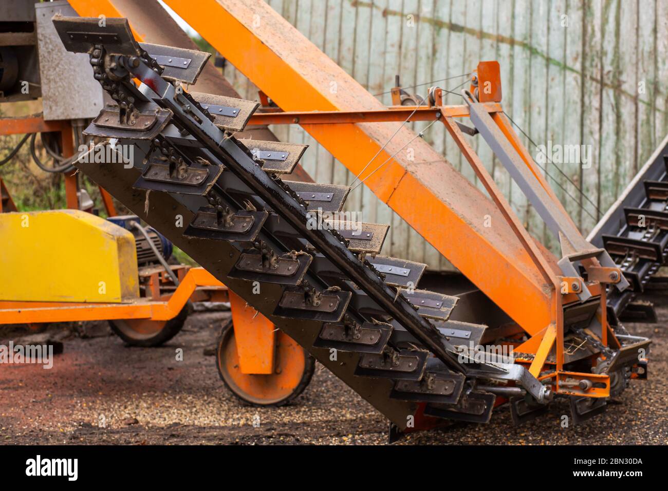 Une machine pour extraire les graines de tournesol dans un hangar. Montagne de graines de