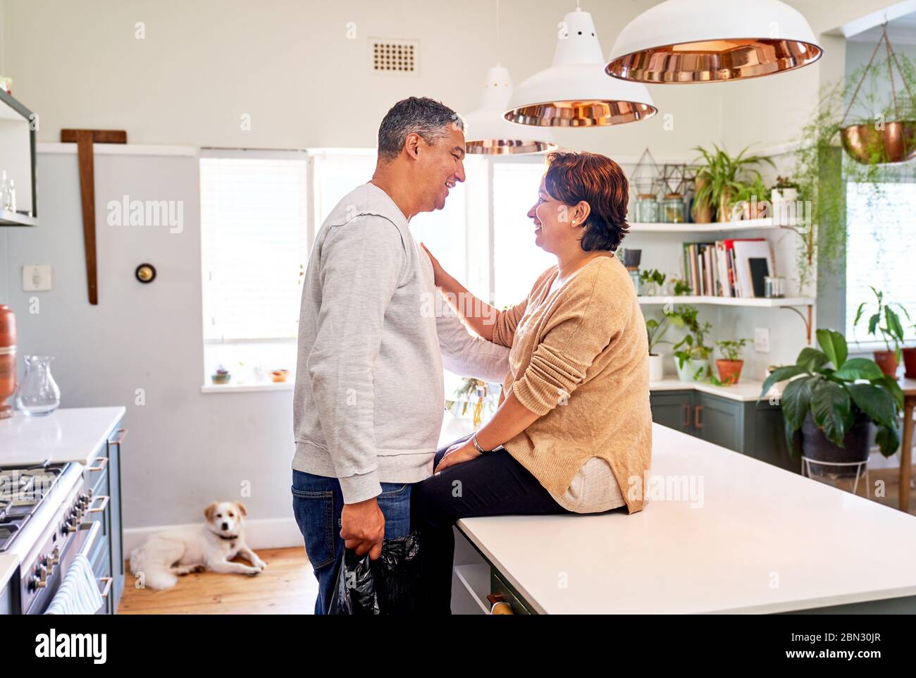 Un couple affectueux et mature qui parle dans la cuisine Banque D'Images