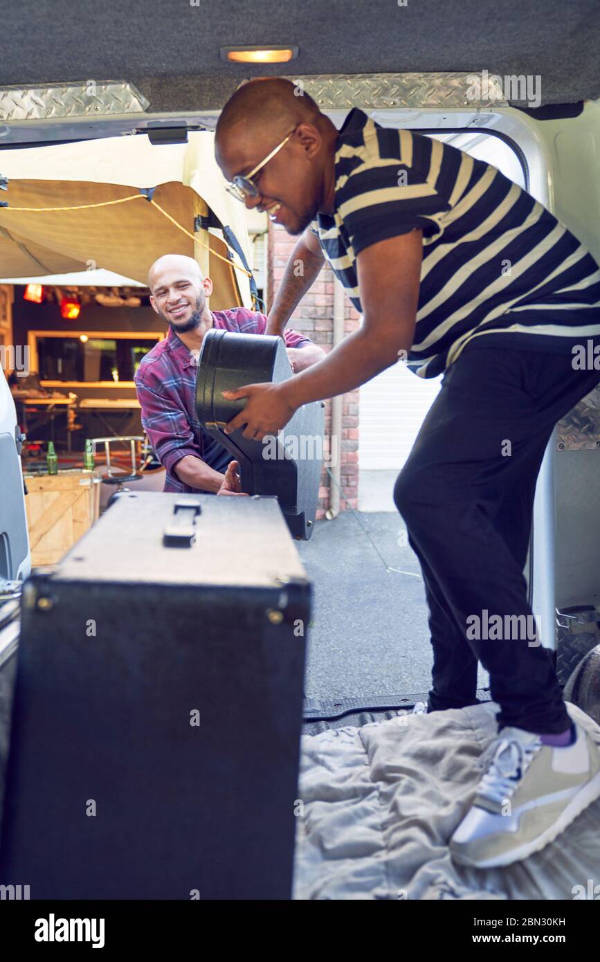 Musiciens de sexe masculin chargeant des instruments de musique dans une fourgonnette Banque D'Images