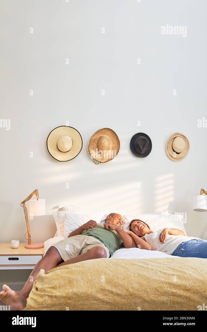 Couple affectueux et heureux se reposant au lit Banque D'Images