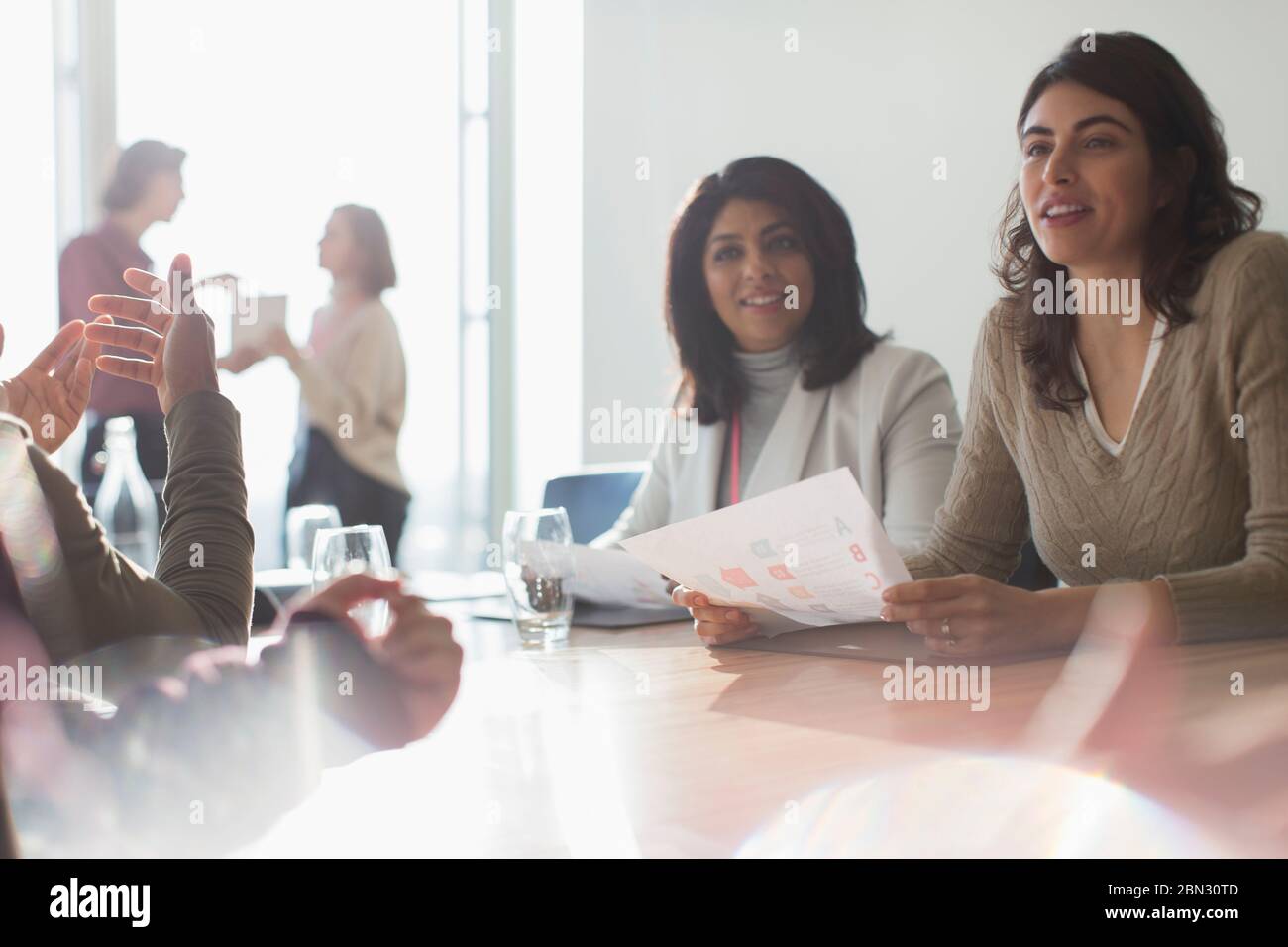 Femmes d'affaires écoutant dans la salle de conférence ensoleillée Banque D'Images