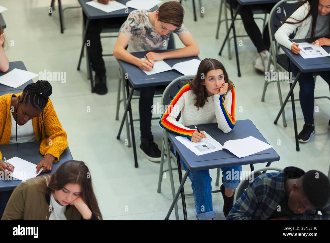 Une jeune fille d'école secondaire qui se présente à l'examen à son bureau en classe Banque D'Images